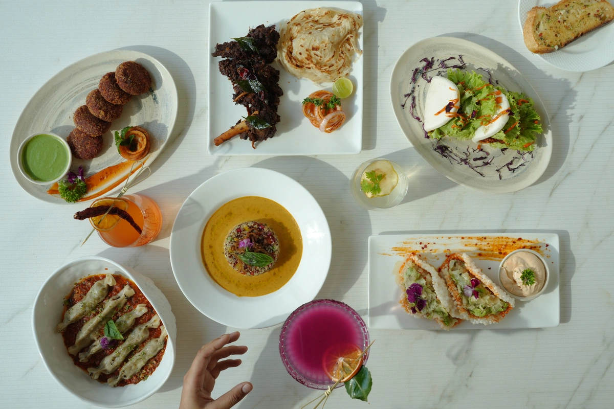 A table spread of dishes and a cocktail at NOUMA